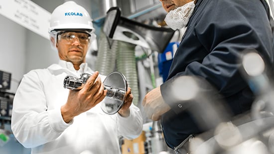 Ecolab expert reviewing a part in a facility