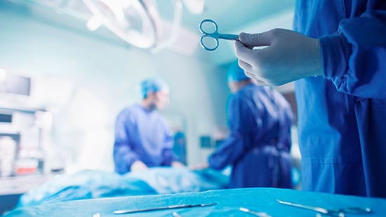 Doctor or nurse holding an instrument in a hospital operating room