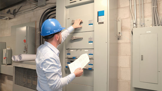 Nalco Water expert inspecting industrial control panel.