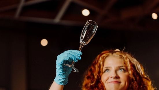 Restaurant / Bar server checking clean glass wearing glove