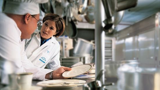 Female white TM talking with white male chef about dishware