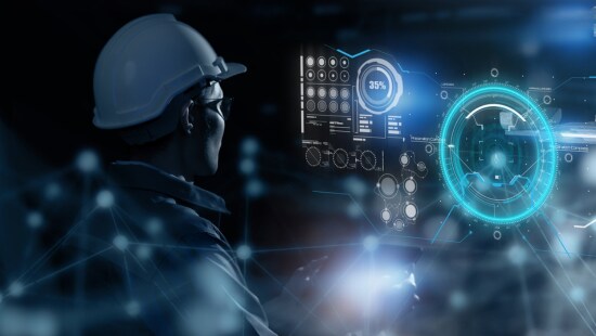 Engineer in hardhat with futuristic technology screen.